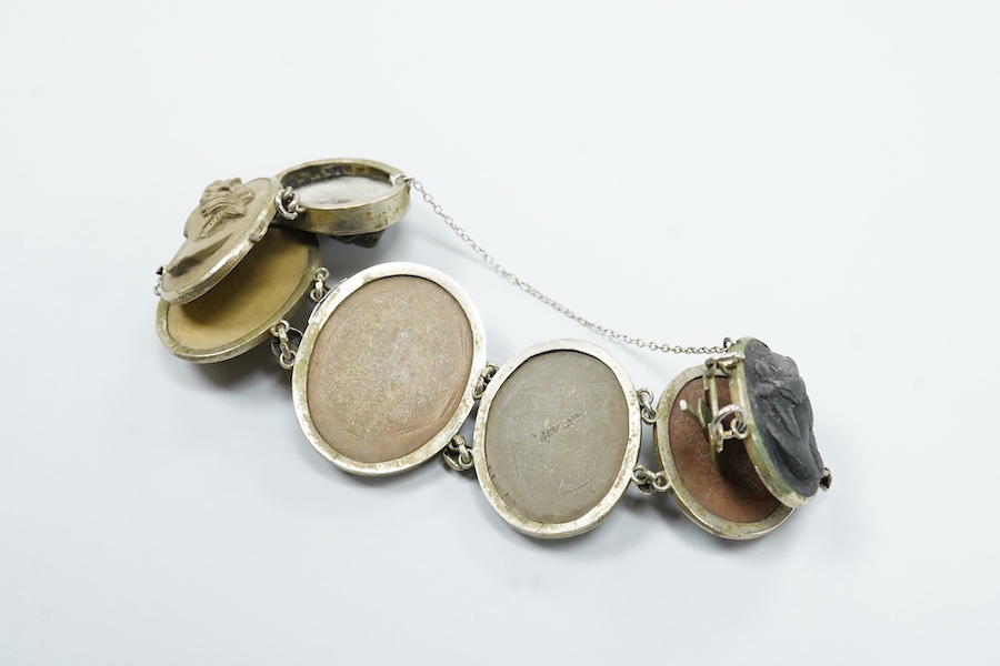 A Victorian base metal bracelet, set with seven graduated lava cameos, carved with the busts of lady's to dexter and sinister, approximately 16.5cm.